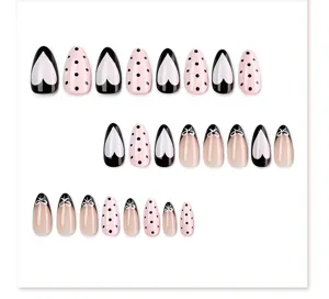 Cute black and pink press on nails featuring heart, polka dot and bow designs for trendy wear.
