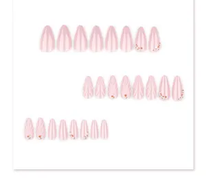 Gros plan de faux ongles courts en amande avec reliefs 3D et décorations en perles.