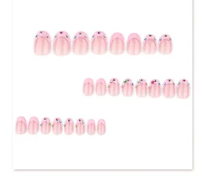French pink short round press-on nails with sparkling rhinestones, exquisite detail shot.