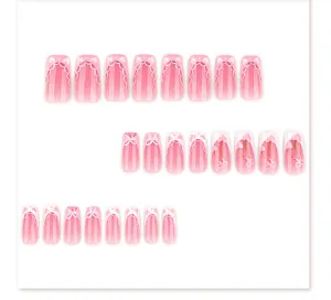 Sweet pink press-on nails featuring cute heart and bow details, perfect for a charming look.