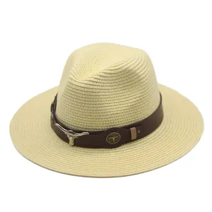 Chapeau fedora en paille beige élégant avec bande en cuir marron et crâne de taureau en métal.