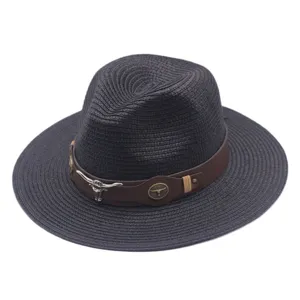 Gros plan détaillé d'un chapeau de paille sombre avec bande en cuir et crâne de taureau.