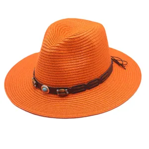 Detail de chapeau de paille orange avec texture tressée fine et bande en cuir décorative