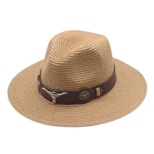 Vue détaillée du chapeau de paille avec bande en cuir marron et décoration de taureau.