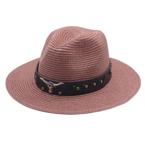 Vue détaillée chapeau fedora paille femme avec bande cuir et ornement crâne taureau métal.
