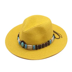Vista ravvicinata dettagliata del cappello di paglia giallo con nastro di perline turchesi.