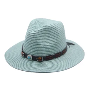 Gros plan détaillé du chapeau fedora en paille vert menthe, avec bande en cuir et perles.
