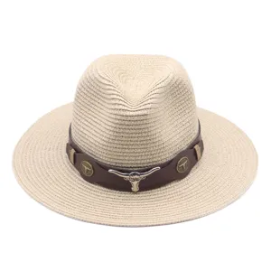 Gros plan sur un chapeau de paille élégant avec bande en cuir marron et décor de crâne.