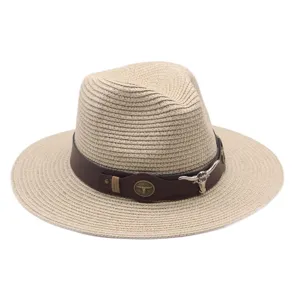 Chapeau de paille beige tissé avec bande en cuir marron et emblème tête de taureau.