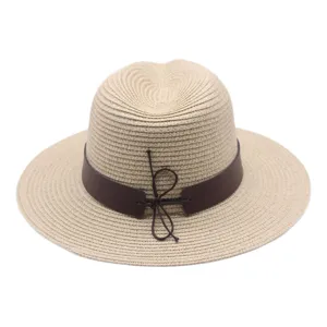 Vue détaillée du chapeau de paille d'été avec tissage beige classique et ceinture en cuir.