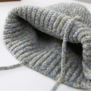 Primo piano dettagliato della trama del cappello secchiello in maglia con coulisse.
