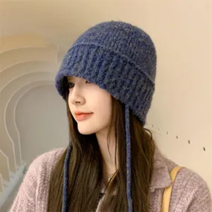 Chic cappello secchiello in maglia con cordoncini decorativi da donna, accessorio invernale.