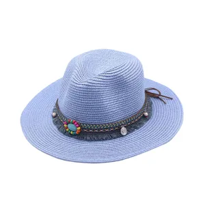 Primer plano detallado del sombrero de paja azul con cinta étnica y cuentas de colores.