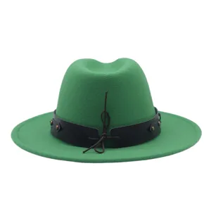 Vista detallada del sombrero fedora verde con banda de cuero negro y detalles de tachuelas.