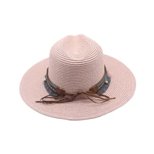 Sombrero fedora de paja rosa estilo bohemio con banda tejida flecos y lazo de cuero.