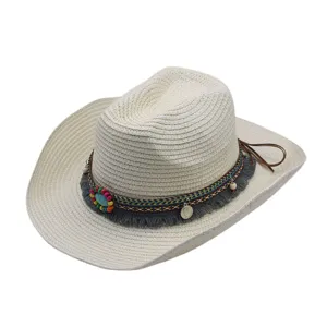 Gros plan du chapeau de paille tissé ethnique avec perles colorées, franges et bande tressée.