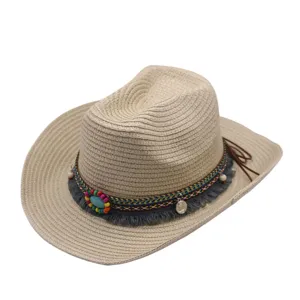 Gros plan détail du chapeau de paille bohème avec perles colorées et décorations turquoises.