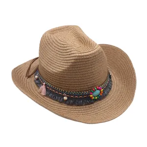 Détail du chapeau de paille ethnique avec bande tissée colorée, perles et glands élégants.