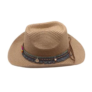 Détail en gros plan du chapeau de cowboy en paille avec bande tressée colorée et franges.