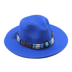 Dettaglio cappello di paglia blu, decorato con perline turchesi e perle di legno.