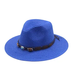 Vue détaillée du chapeau de paille bleu avec bande en cuir marron et perles pour l'été.