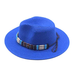 Vista dettagliata di un cappello di paglia blu con fascia di perline boho e laccio in pelle.