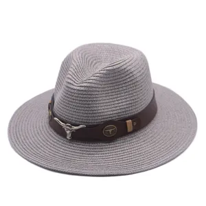 Vue détaillée du chapeau fedora en paille grise avec bande en cuir marron et crâne de taureau.