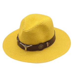 Vue detaillee du chapeau de paille jaune avec bande en cuir marron et decor de crane de taureau.