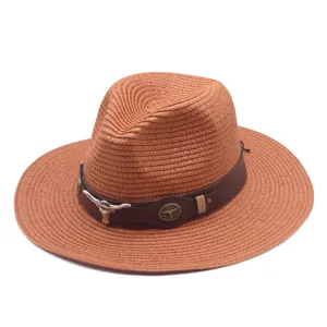 Gros plan détaillé du chapeau de paille marron avec bande en cuir et décor de crâne de taureau.