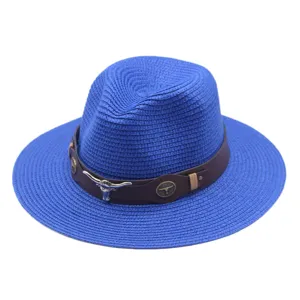 Vue détaillée du chapeau de paille bleu avec bande en cuir et ornement tête de taureau.