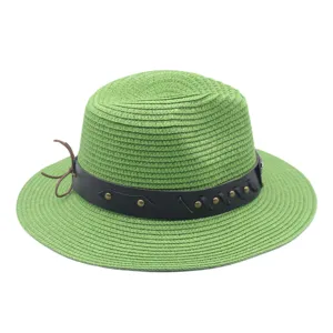 Détail chapeau paille vert, avec bande cuir noir, clous métalliques et nœud décoratif latéral.