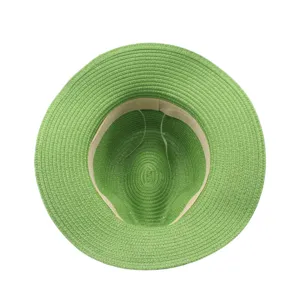 Vue détaillée de l'intérieur d'un chapeau de paille vert, montrant le tressage et la bande de sueur.