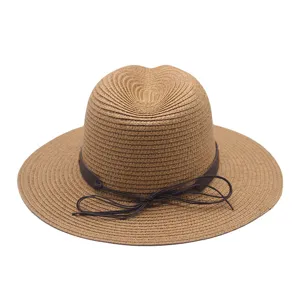 Vue détaillée du chapeau de paille marron avec un élégant bandeau en cuir marron foncé.