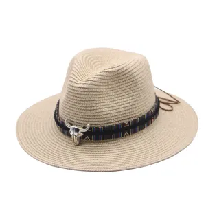 Detailed view of tribal style straw fedora hat with metallic bull skull and woven ribbon.