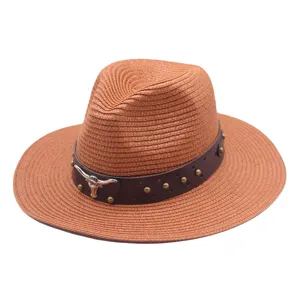 Close-up detail of the woven straw hat, brown leather band with metal studs and bull skull.