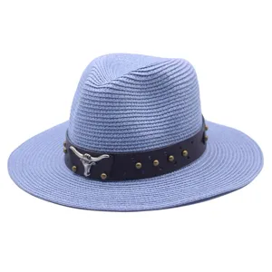 Detailed view of light blue straw fedora hat with brown leather band and bull skull emblem.
