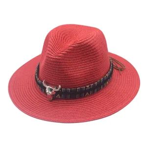 Red straw fedora hat detail featuring ethnic pattern band and metal bull skull decoration.