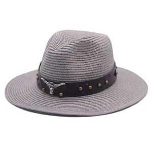 Detail shot of a grey woven fedora straw hat with dark leather belt and metal bull decor.