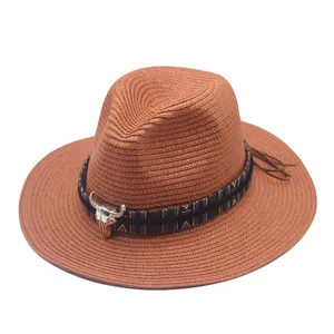 Brown straw fedora hat detail, featuring ethnic woven band and silver bull skull accent.