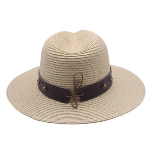 Straw hat detail view, beige woven panama sun hat featuring brown leather band and rivets.
