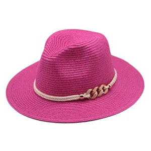 Détail de chapeau fedora en paille fuchsia, élégante corde blanche et chaîne dorée pour le soleil.