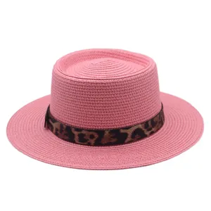 Roze platte strohoed detail met stijlvolle luipaardprint band voor zomerse strandvakanties.
