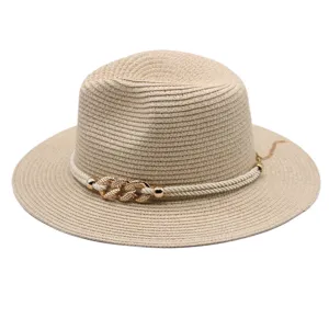 Vue de détail d'un chapeau de paille beige avec corde blanche et chaîne dorée pour l'été.