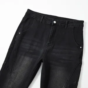 Gros plan détaillé d'un jean homme en denim noir stretch lavé avec ceinture et empiècements.