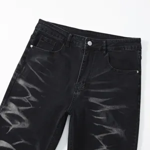 Dettaglio in primo piano di jeans da uomo neri slavati con motivo tie-dye unico.