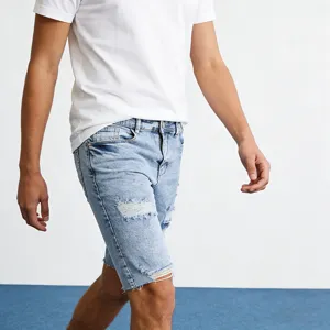 Pantaloncini di jeans strappati azzurro chiaro da uomo stile streetwear vista dettaglio.