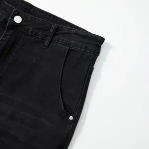 Gros plan détaillé d'un jean en denim extensible noir avec la ceinture et la poche.