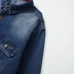 Close-up of mens long sleeve washed denim shirt featuring classic lapel collar and chest pocket.