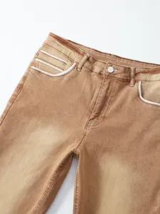 Jeans slim elasticizzati marroni da uomo vista dettaglio con tasche a contrasto e bottone.