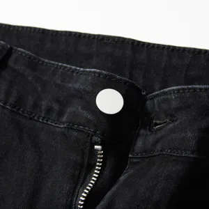 Détail de jean noir lavé pour hommes présentant un tissu extensible et fermeture éclair.